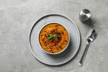 Sweet potato puree in bowl, plate, spoon and salt on gray background, top view