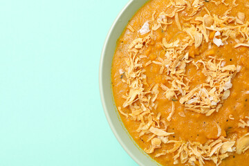 Sweet potato puree in bowl on green background, space for text