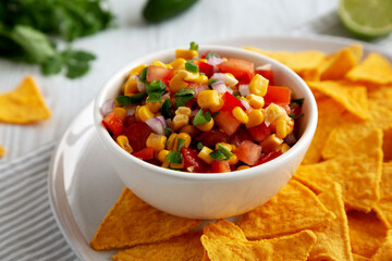 Homemade Corn Salsa with Tortilla Chips on a Plate, low angle view.