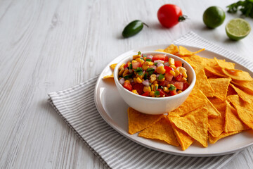 Homemade Corn Salsa with Tortilla Chips on a Plate, low angle view. Copy space.