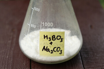 A mixture of white powders of boric acid and soda ash in a flask to prepare a solution for treating...