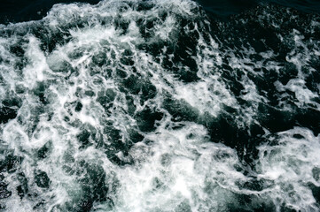 Obraz premium White foam in the sea from a sailboat.Blue water of different shades in the ocean mixed with white foam in Buracona the blue eye cave.Deep Blue Ominous Ocean Water abstract Background Image.