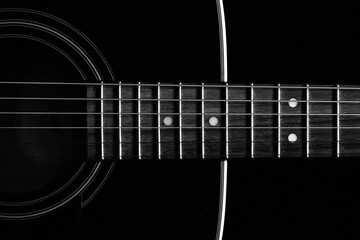 Closeup shot of details on a glossy black acoustic guitar