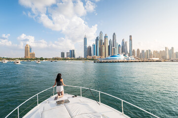 Woman Enjoying a Sunset Yacht Ride in Dubai Marina Harbor in the UAE - 686117485