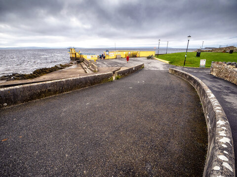 Footpath leading to Blackrock diving board, Salthill area, Galway city, Ireland. Popular town landmark loved by local people and international tourists. Cloudy sky. Travel and tourism hot spot.