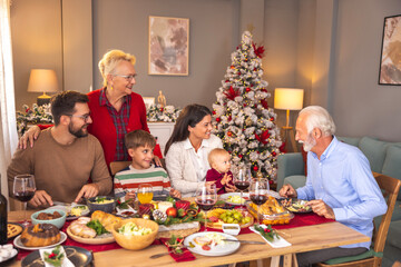 Multi-generation family having Christmas dinner together at home