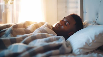 Gardinen African-American man sleeps under warm plaid on soft bed at home closeup. Handsome black guy dreams lying on pillows in cozy bedroom. Young man naps comfortably in semi dark hotel room © Stavros