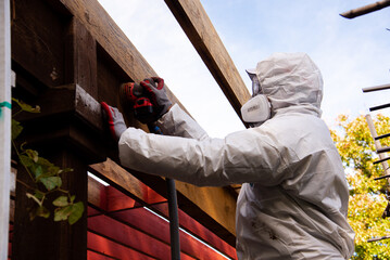 Asian man in full body hazmat suit, respirator mask, gloves, safety glasses goggles protection...