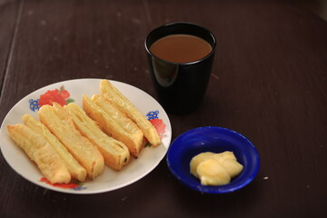 On a white dish with an isolated brown background, Indian khari is presented with salted butter and masala chai. High Resolution