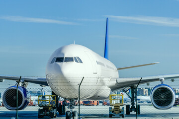 An airplane loads on the runway receiving inspection, cleaning and fuel - obrazy, fototapety, plakaty