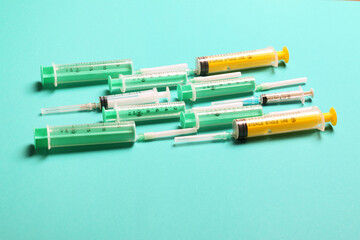 Top view of medical syringes with needles at blue background with copy space. Injection treatment concept