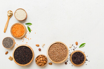 Various superfoods in smal bowl on colored background. Superfood as rice, chia, quinoa, lentils, nuts, sesame seeds, almonds. top view copy space