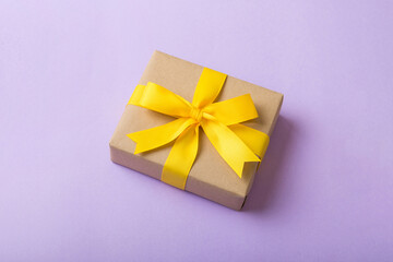 Wrapped christmas or other holiday handmade present in craft paper with colored ribbon. Present...