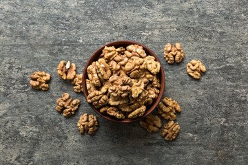 Fresh healthy walnuts in bowl on colored table background. Top view Healthy eating bertholletia concept. Super foods