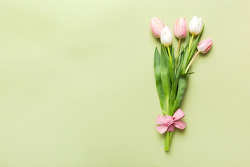 Bouquet of pink tulips on colored table background . Top view with copy space. Waiting for spring. Happy Easter card. Flat lay