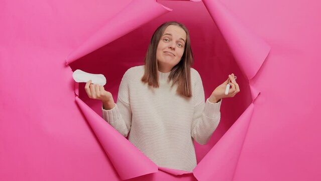 Protective care for women health, fertilization. Cheerful woman holding cotton tampon and sanitary napkin having positive look monthly menstrual cycle.