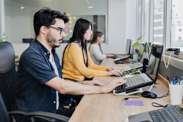 Group of multicultural coworkers at the office working on laptops