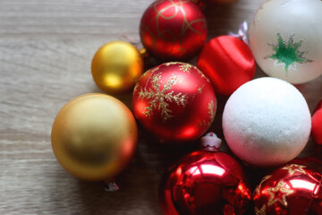 Pine cones and red, golden and white Christmas ornaments on wooden background. Selective focus.