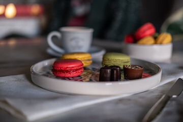 Colorful macarons and filter coffee on a blue plate