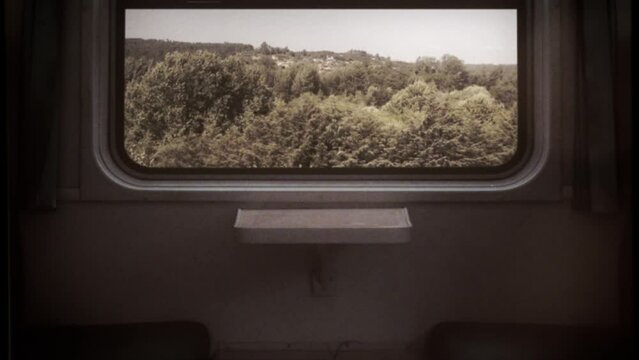 Train Travel Retro 16mm Empty Seats Window View Countryside Old Film Texture. Window view from a train traveling across the countryside, empty seats. 16mm vintage style