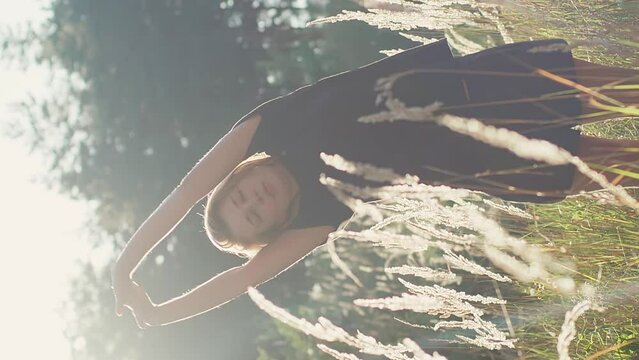 Athletic caucasian girl stretching in a wheat field after work out, athlete sport recreation post-workout recovery vertical