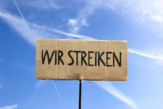 wir streiken - protestschild vor blauem himmel
