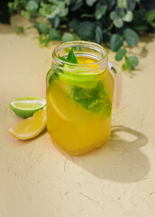 Lemonade with fresh orange, lime and mint in glass jug