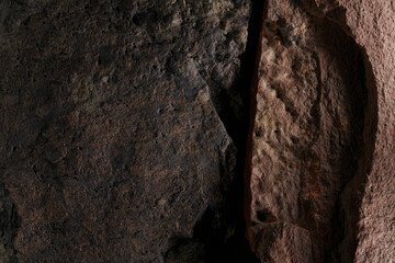 Brown stone texture, dark abstract background. Natural mineral rock close up details, empty backdrop with copy space for design