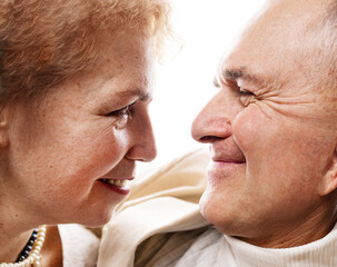 Portrait of a happy senior couple embracing each other against white background