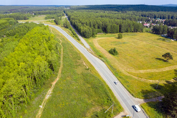 Naklejka premium Top view of the movement of cars on the motorway through the forest