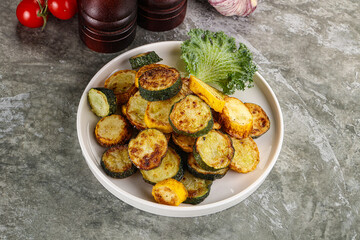Roasted young zucchini in the plate