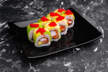 sushi rolls wrapped with avocado and shrimp inside