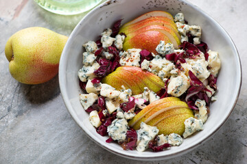 Grey bowl with chopped radicchio, pear slices and blue cheese salad, middle close-up, horizontal shot