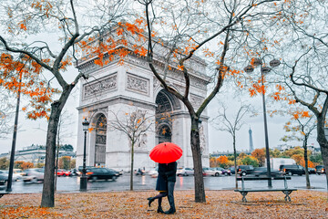 Couple under umbrella in front of Arc de Triumph, Paris - obrazy, fototapety, plakaty