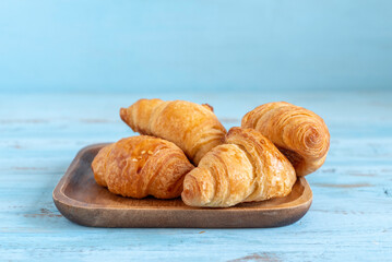 Fresh croissant on wooden background.