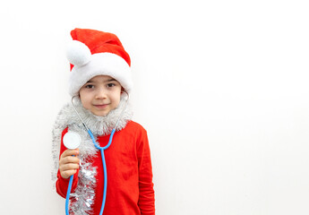cute boy with santa claus cap and stethoscope playing with teddy bear,listening patient breathing,heartbeat.preschooler kid in red clothes with garland and tangerine covering eyes.candy cane as heart