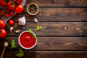 Tomato sauce passata in bowl with fresh tomatoes and basil