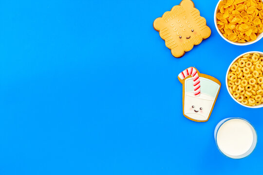 Flat lay of food for kids - milk with cornflakes and biscuits, top view