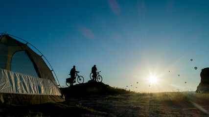 Cyclists who camp and wait for the sunrise enjoy Cappadocia by watching the balloons.