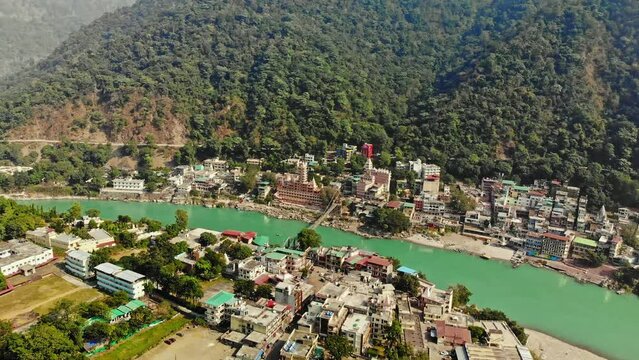 Aerial/Drone shot of Rishikesh City, Ram Jhula bridge situated on Holy River Ganga in Rishikesh, holy town and travel destination in India, Hindus capital 4k