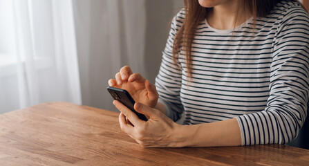 Portrait of a young woman holding a cell phone to use social networking on a smartphone