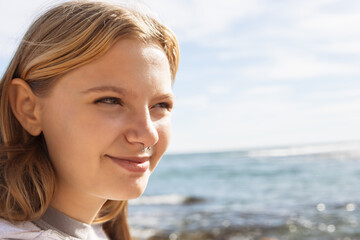 portrait of a teenage girl with a nose piercing against the background of the sea