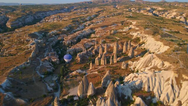 Aerial video. Captured against the canvas of the Cappadocian sky, this video showcases the enchanting spectacle of a hot air balloon festival. One blue ballon gracefully glides among distinctly shaped