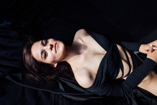 Beautiful slender woman in black lingerie in bedroom on bed