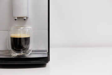 close up of coffee machine with double wall glass of espresso