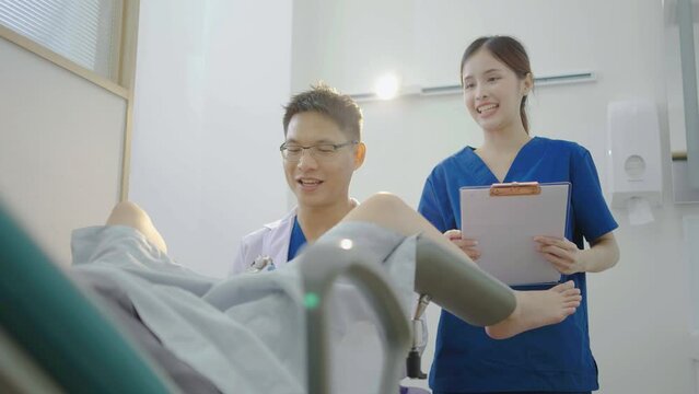 Male asian doctor doing internal examination on female patient at hospital room. They discussing about Illness with female patient at hospital, gynecological examination, conducting a pelvic exam