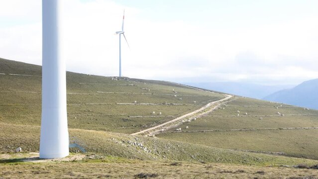 Wind farm with turbines on the mountains. Eco-sustainable industry with nature-friendly technologies for clean energy in a better environment. Conceptual mountainous landscape  