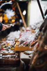 Christmas market. A table with Christmas products on display. Sweets and gingerbread. Ferris wheel and Christmas trees in the background. Christmas lights. Winter seazon.