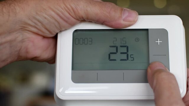 Central heating thermostat control panel. Handheld device used to control the temperature in the home. Monitoring power usage helps to save on energy costs over the winter period. 
