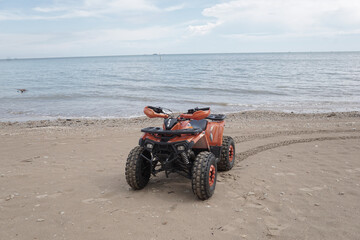 Obraz premium ATV Parked at seashore on clean beach with beautiful skies